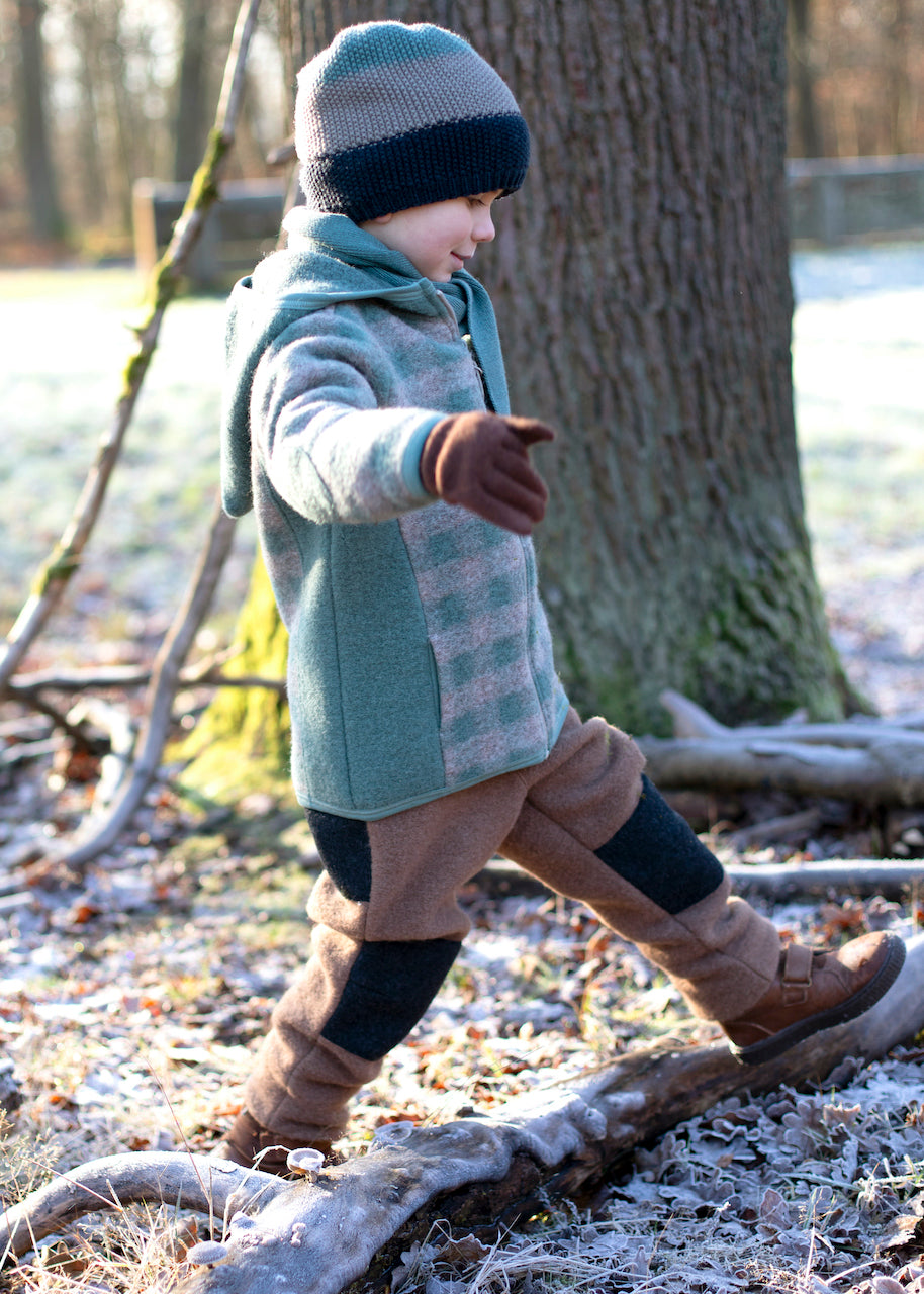Kind trägt Wollwalk Jacke im salbei-kaschmir Karo beim Spielen im Freien. Pure Pure by Bauer, Bärechind Winterthur Zürich Schweiz.