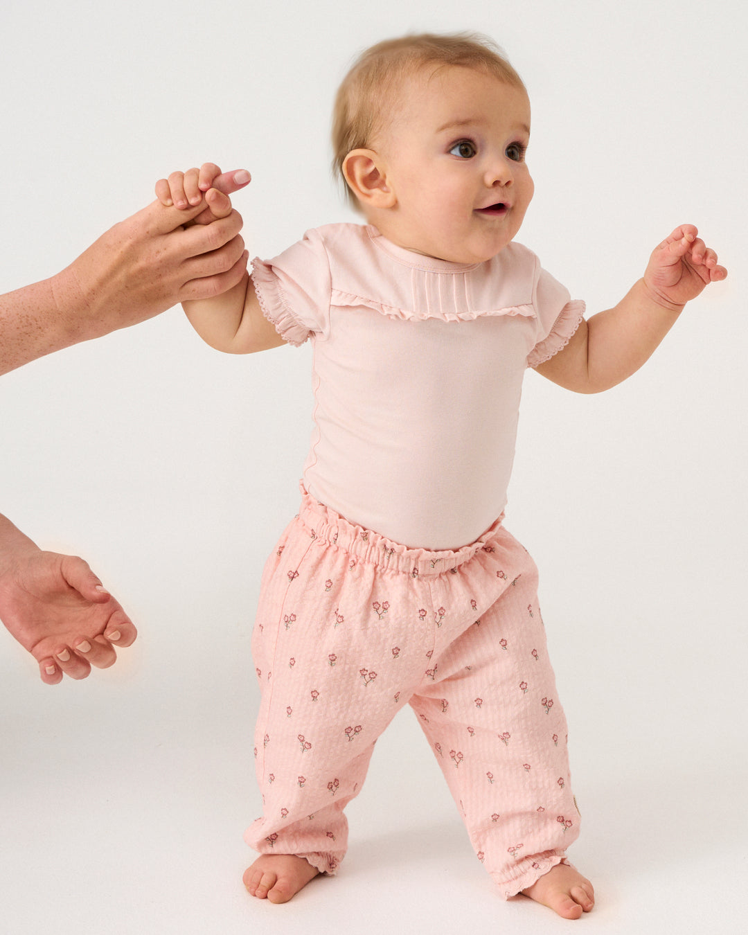Baby trägt Minymo Kurzarm Body in Rose aus Bio-Baumwolle im Bärechind Winterthur, Zürich, Schweiz