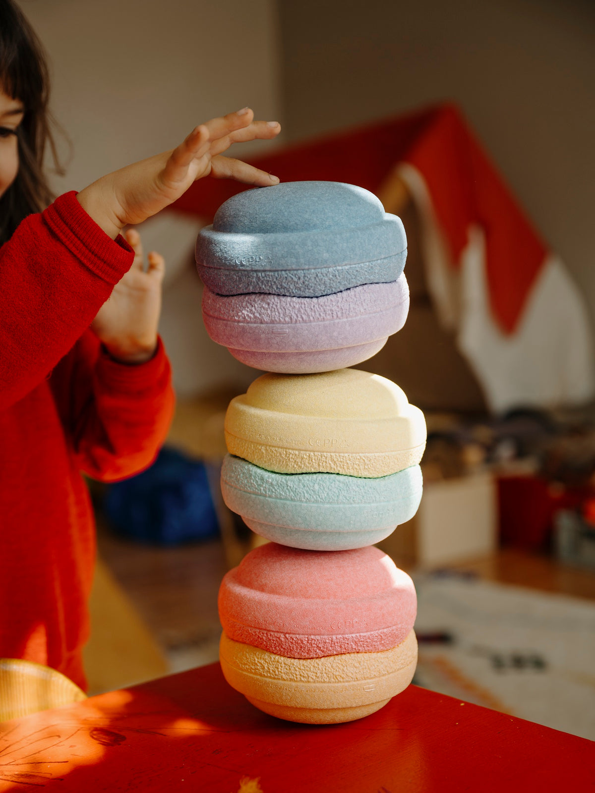 Kind stapelt das Stapelstein Mini Rainbow Pastell Set – farbenfrohes Spiel im Bärechind