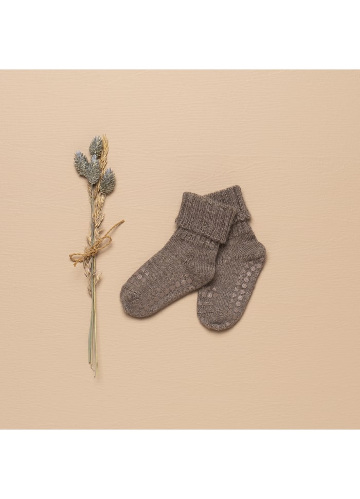 GoBabyGo Babysocken aus Alpakawolle in Braun – stimmungsvolle Stillleben-Aufnahme mit Trockenblume