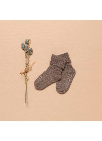 GoBabyGo Babysocken aus Alpakawolle in Braun – stimmungsvolle Stillleben-Aufnahme mit Trockenblume