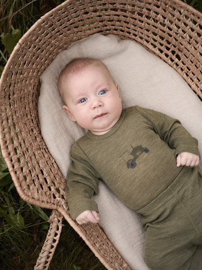Baby trägt CeLaVi Langarmbody mit Traktormotiv in Dusky Green – zu finden im Bärechind in Winterthur, Zürich, Schweiz.