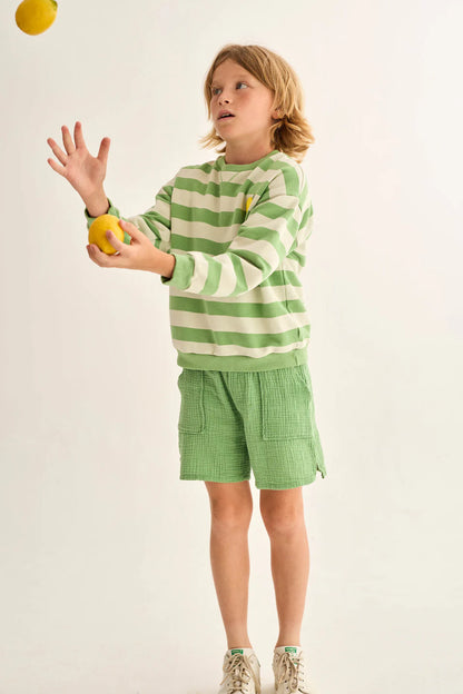 Kind trägt grüne Cozmo Musselin Shorts Cove – nachhaltige Sommermode für Kinder im Bärechind Winterthur