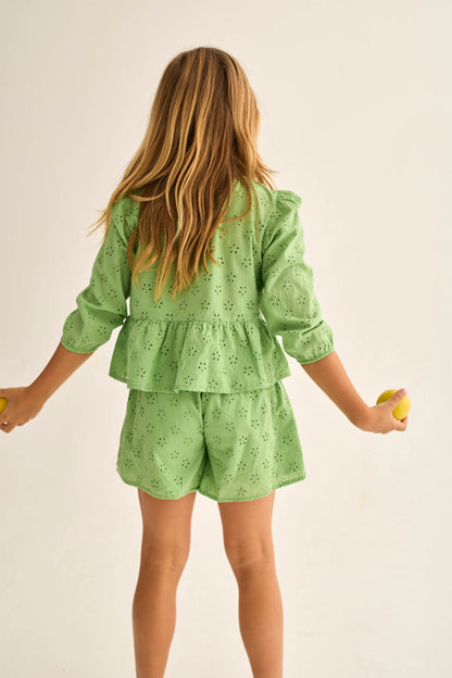 Kind trägt grüne Cozmo Shorts Ruby aus Lochstickerei – luftige Kinder Shorts im Kinderladen Winterthur