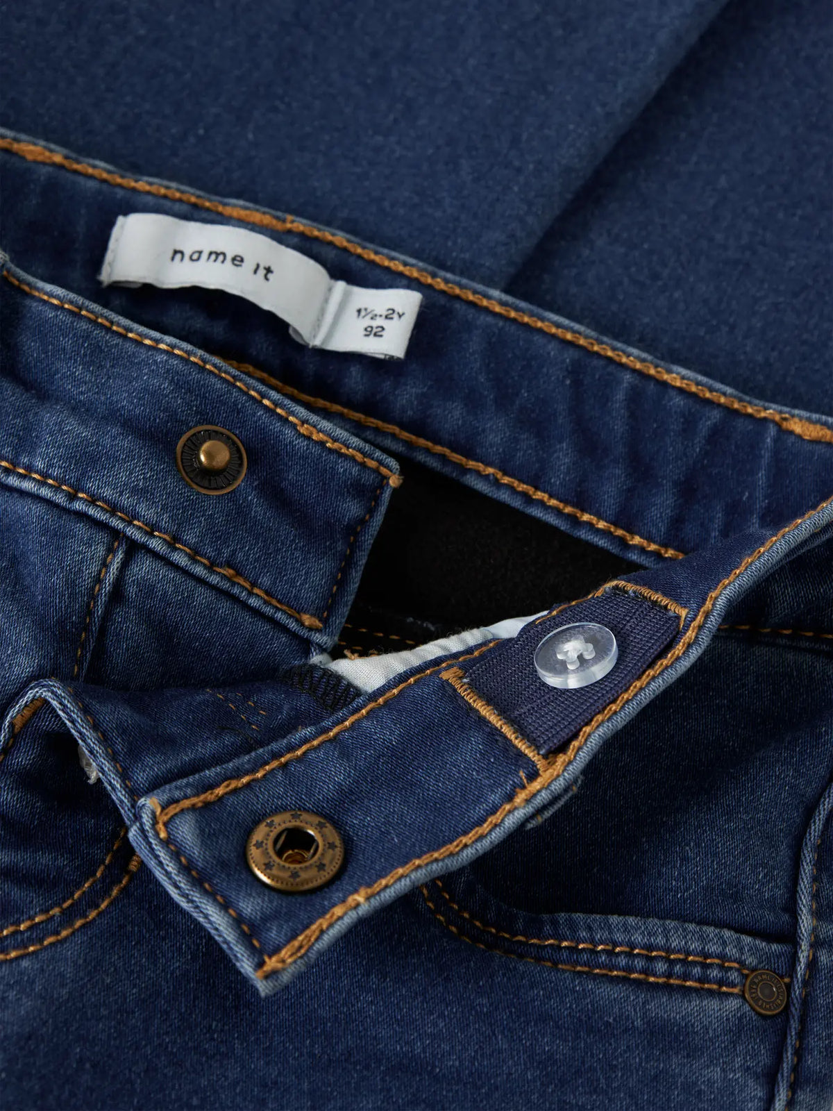 Detailaufnahme Bund und Knopf einer Bootcut Kinderjeans aus Denim mit Fleece-Innenseite, Bärechind Winterthur Zürich Schweiz