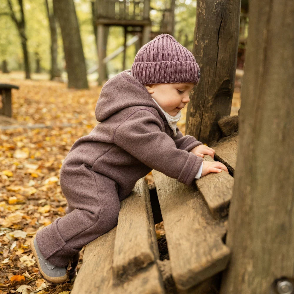 Kind im Emma & Noah Wollwalk Overall aus Merinowolle in Essential Berry