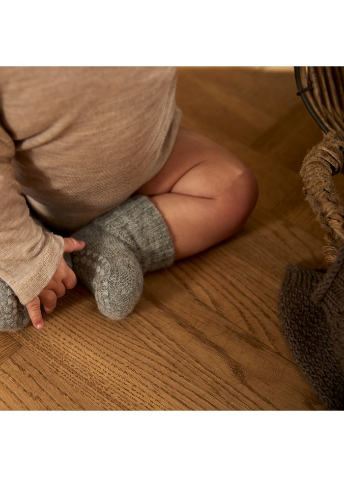 Detailaufnahme von Babyfüssen in Alpakasocken – warm, rutschfest und ideal für Wintertage