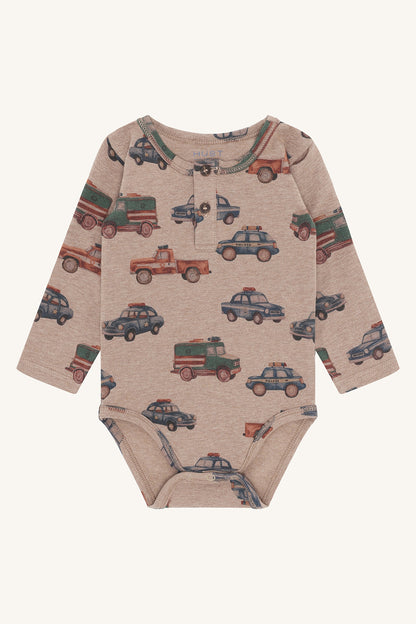 Babybody Billy von Hust&Claire in Biscuit mit Polizeiauto-Motiv aus Bio-Baumwolle, erhältlich im Bärechind Winterthur, Zürich Schweiz