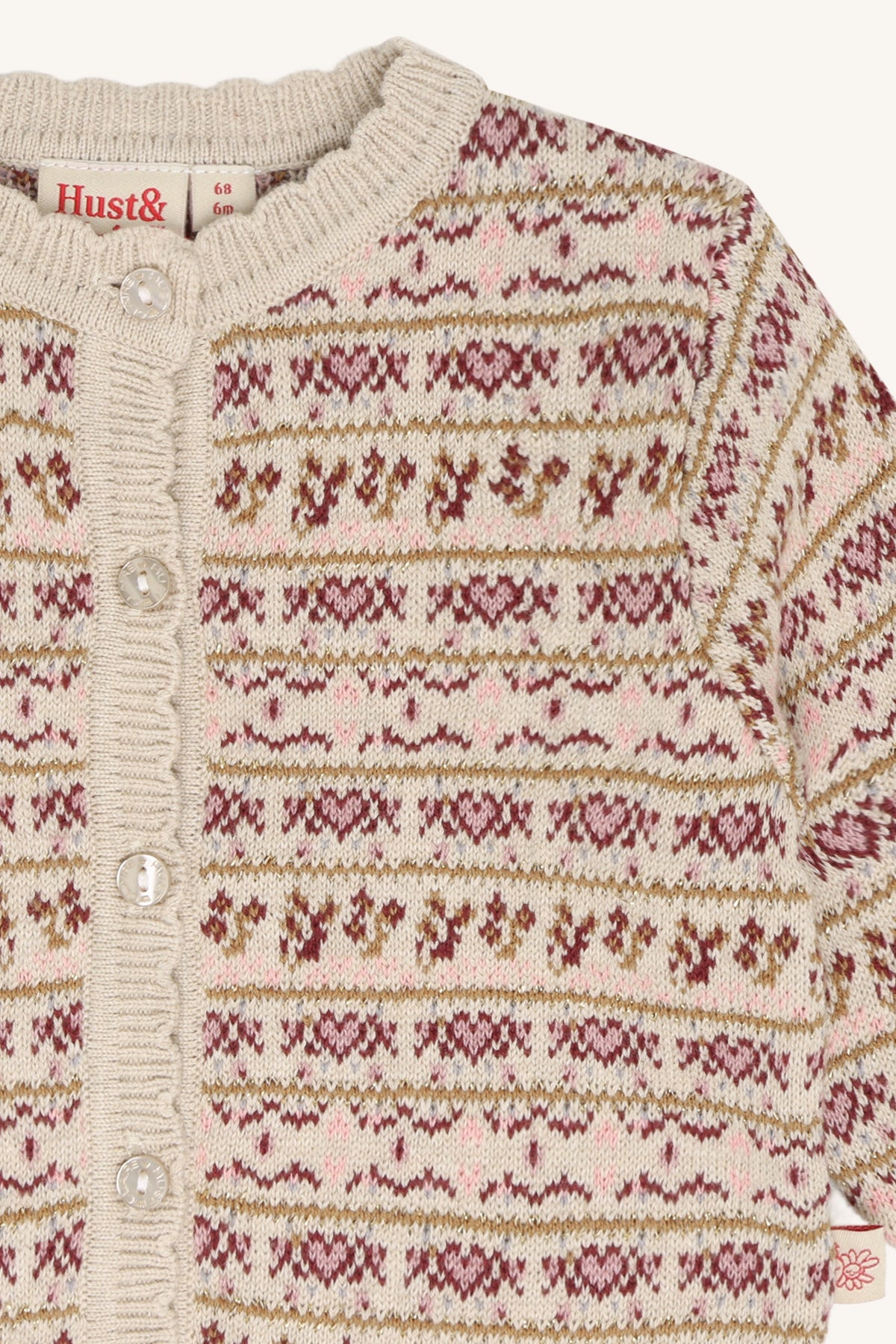 Detail der Hust & Claire Cilja Nordic Kinderstrickjacke mit nordischem Strickmuster, Knöpfen und geripptem Ausschnitt.
