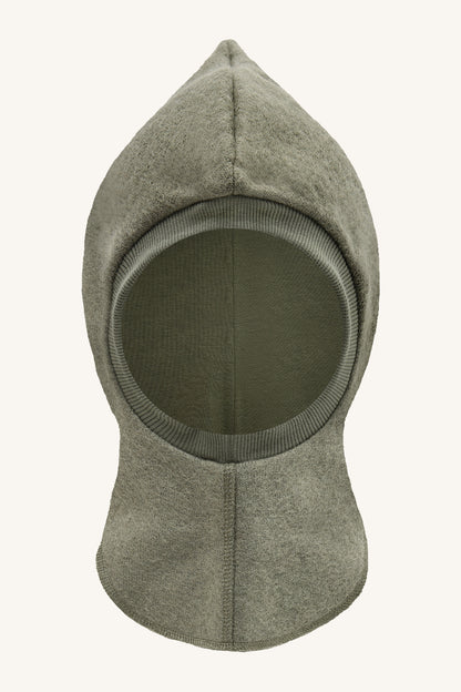 Vorderansicht der Hust & Claire Feo Wollwalk Schlupfmütze in Turtle mit Gesichtsöffnung und wärmendem Halsschutz.