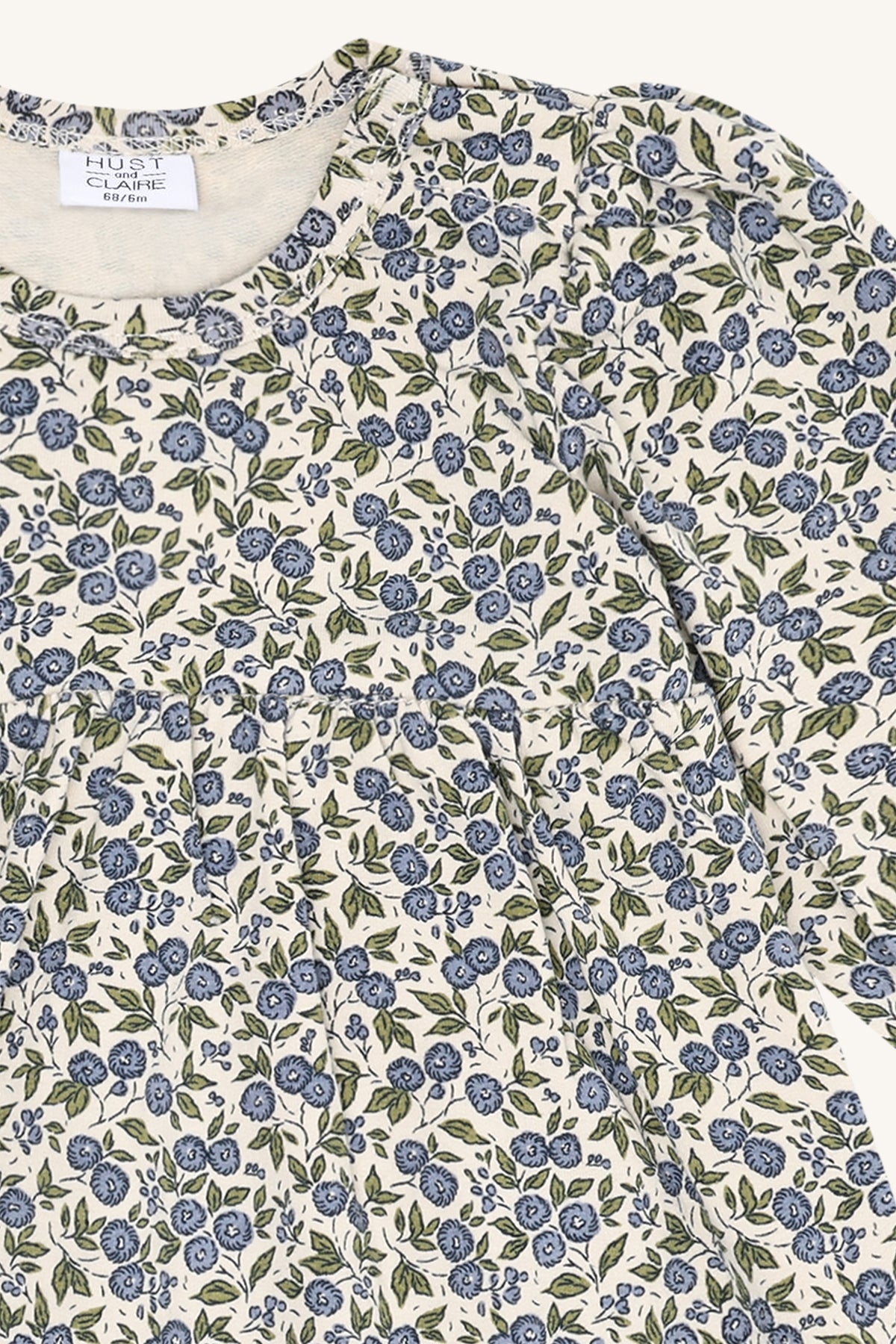 Detailaufnahme des feinen Blumenmusters auf dem Hust & Claire Kis Flora Babykleid in Atmosphere.