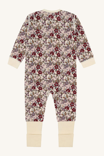 Rückansicht des Hust&Claire Manu Stramplers aus Merinowolle und Bambus mit Blumenprint, Bärechind Winterthur Zürich Schweiz.