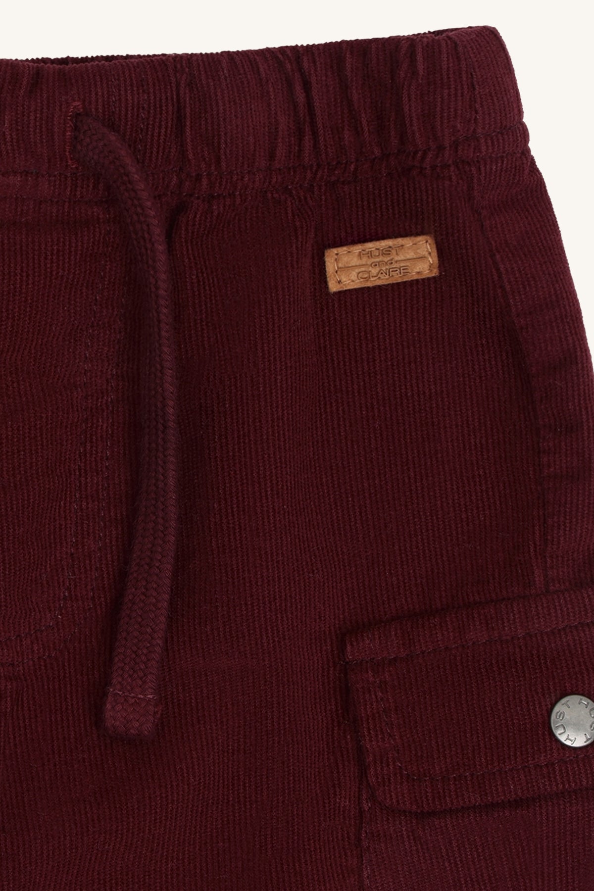 Detail der Hust & Claire Tue Cordhose in Red Chocolate mit Bindeband, Cordstruktur und seitlicher Cargo-Tasche.