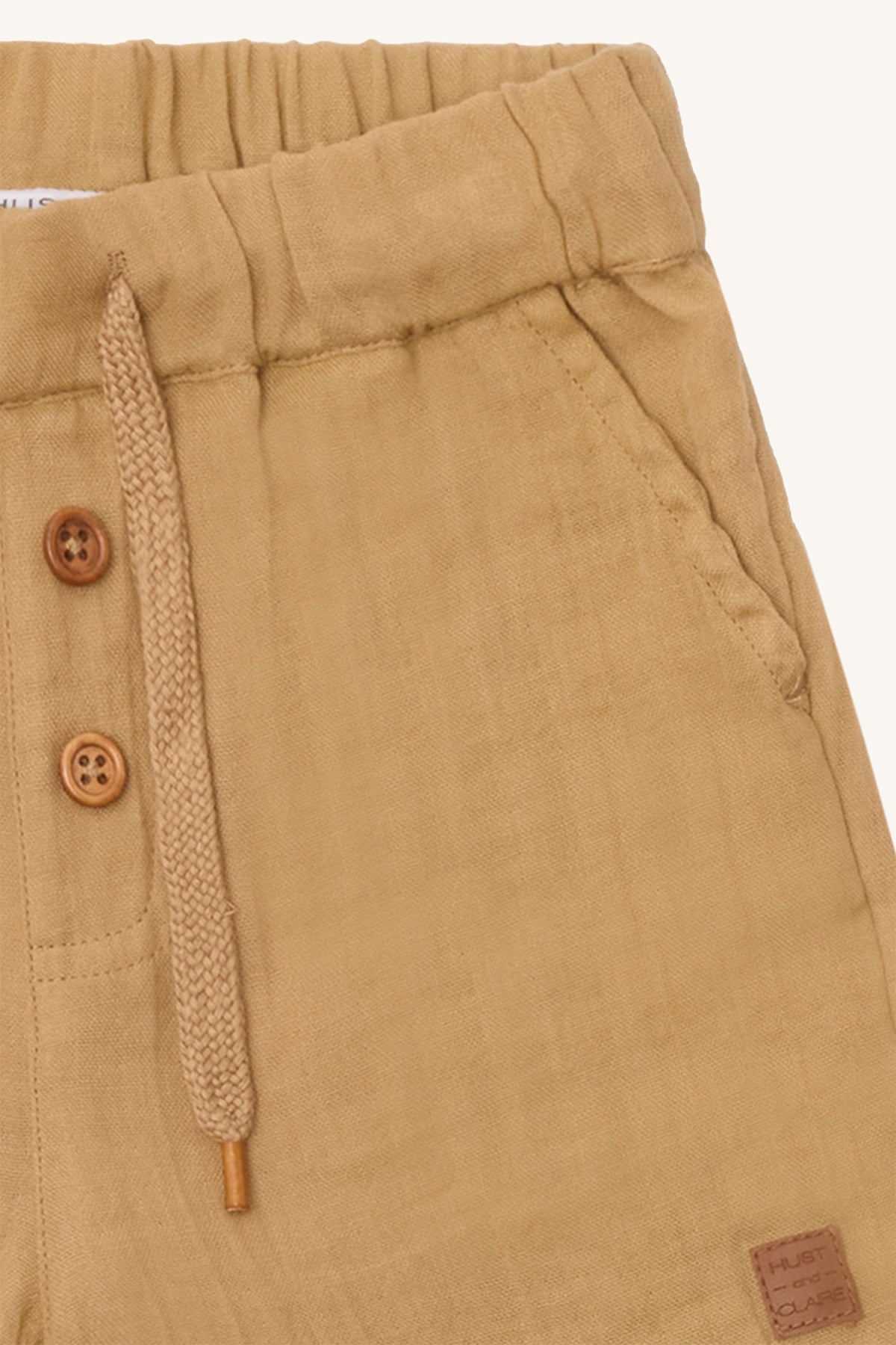 Detailaufnahme der Shorts mit Zierlatz und Knöpfen in Holzoptik – nachhaltige Kindermode von Bärechind in Winterthur, Zürich, Schweiz.