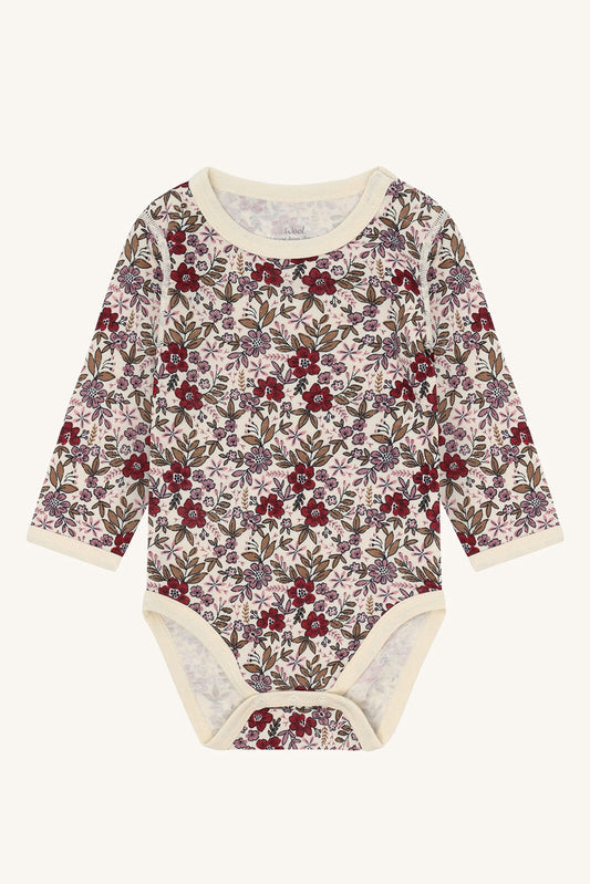 Vorderansicht Hust&Claire Baloo Body aus Wolle/Bambus mit Blumenmuster – erhältlich im Bärechind Winterthur, Zürich, Schweiz.