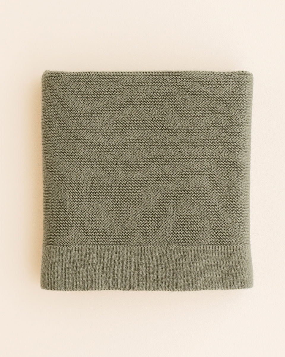Hvid Merino Babydecke Gust in Artichoke Grün, gestrickt aus Merinowolle, erhältlich im Bärechind in Winterthur, Zürich Schweiz.