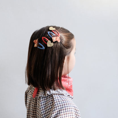 Mädchen trägt Mimi & Lula Pferdekopf Haarclips mit Glitzerherzen, erhältlich im Bärechind Schweiz.