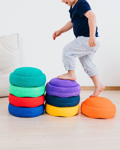Kind hüpft über bunte Stapelsteine – Bewegung und Spiel mit System