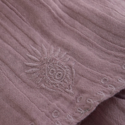 Detailaufnahme des Minymo Musselinrocks in Lila mit feiner Blumenstickerei und weicher Stoffstruktur.