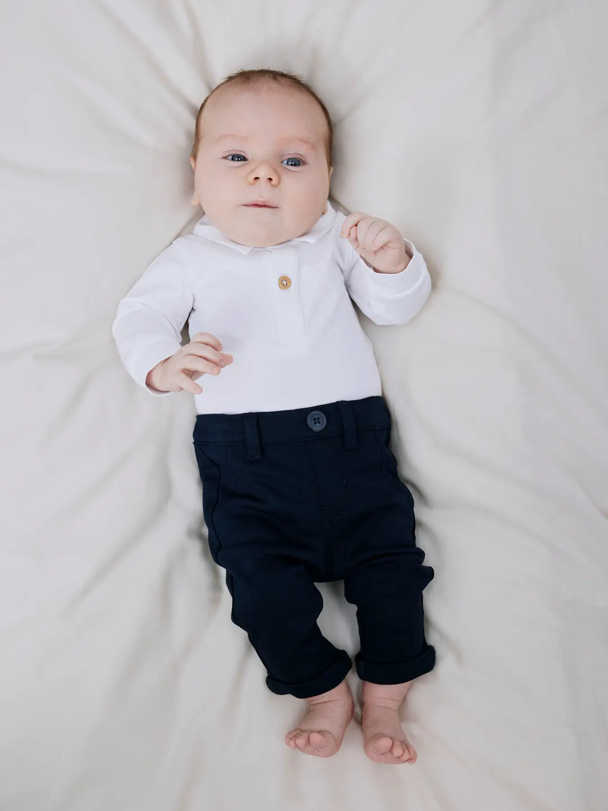 Baby trägt weissen Polo-Body von NAME IT aus Bio-Baumwolle, Bärechind Winterthur Zürich Schweiz.