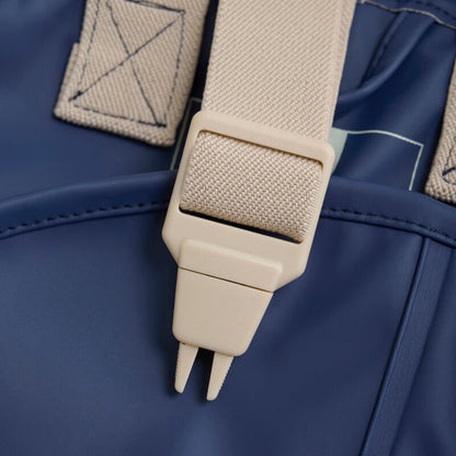 Detailaufnahme der verstellbaren Träger aus recyceltem Material an der Kinderregenhose – lokal erhältlich bei Bärechind in Winterthur, Zürich, Schweiz.